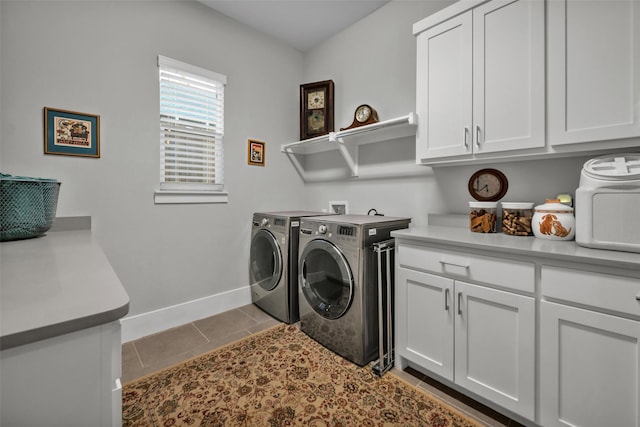 laundry room with cabinet space, washing machine and dryer, baseboards, and tile patterned flooring