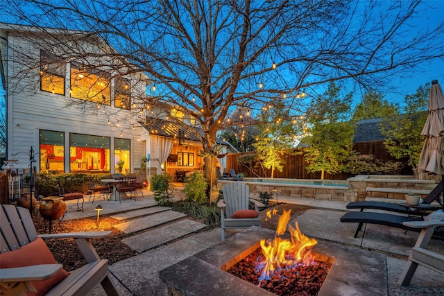 view of patio / terrace with a fire pit, fence, and a fenced in pool