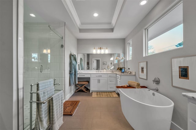 full bath featuring a stall shower, vanity, a tray ceiling, a freestanding bath, and crown molding