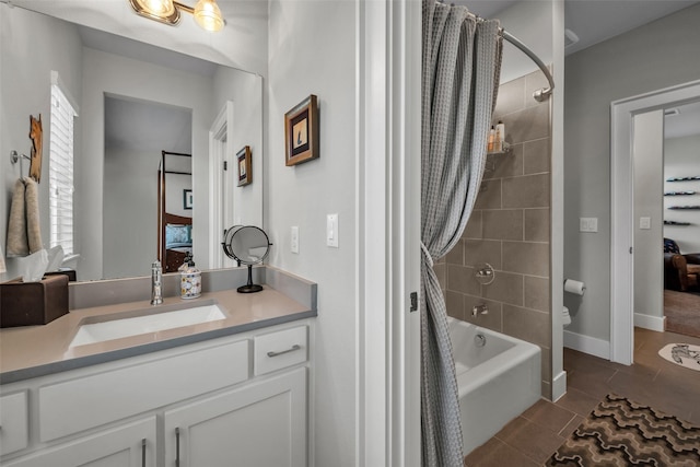 ensuite bathroom with baseboards, vanity, ensuite bath, and tile patterned floors