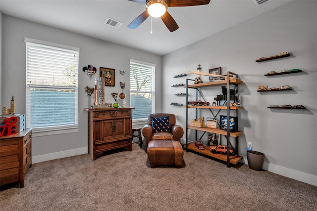 living area with a ceiling fan, carpet, visible vents, and baseboards