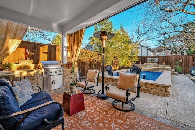 view of patio / terrace with a fenced backyard, a grill, and an outdoor kitchen