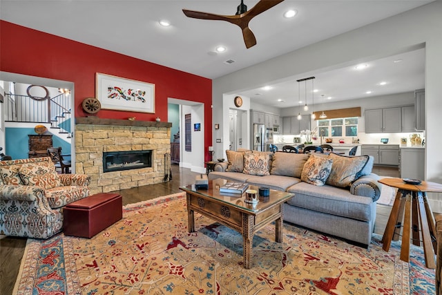 living room featuring recessed lighting, a fireplace, wood finished floors, a ceiling fan, and stairway