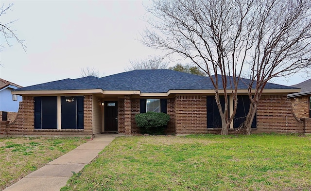 single story home featuring a front yard, brick siding, and roof with shingles