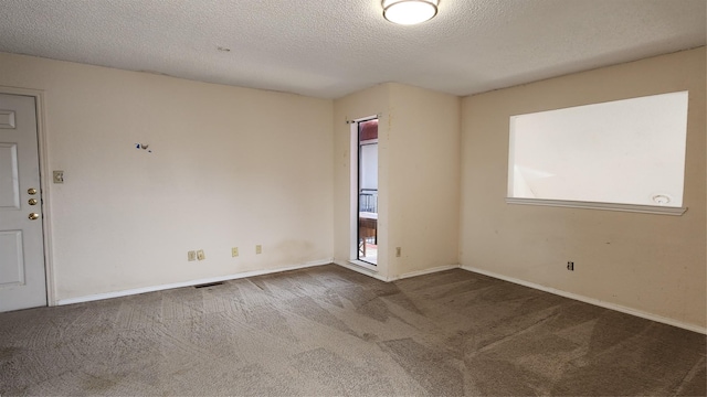 carpeted empty room with a textured ceiling, plenty of natural light, and baseboards