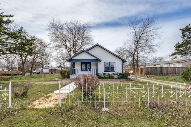 bungalow-style house featuring a front yard, covered porch, and fence