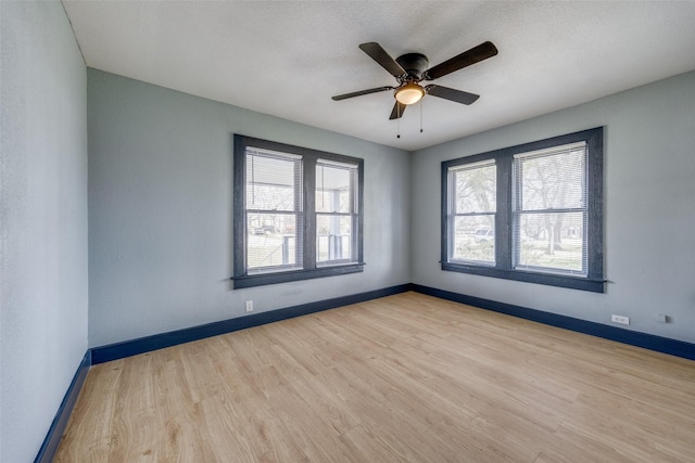 unfurnished room with a ceiling fan, baseboards, and wood finished floors