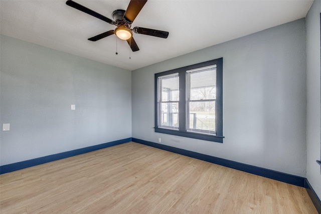 unfurnished room featuring ceiling fan, baseboards, and wood finished floors