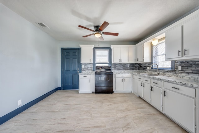 kitchen featuring black range with electric stovetop, a sink, white cabinetry, visible vents, and tasteful backsplash