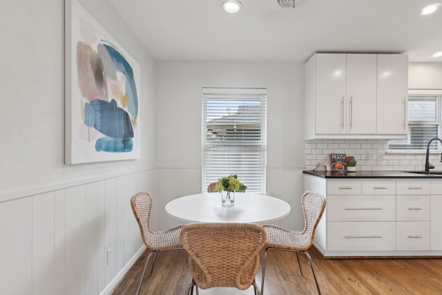 dining area featuring recessed lighting, light wood-style floors, plenty of natural light, and wainscoting