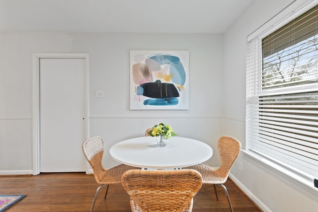 dining space with wainscoting and wood finished floors