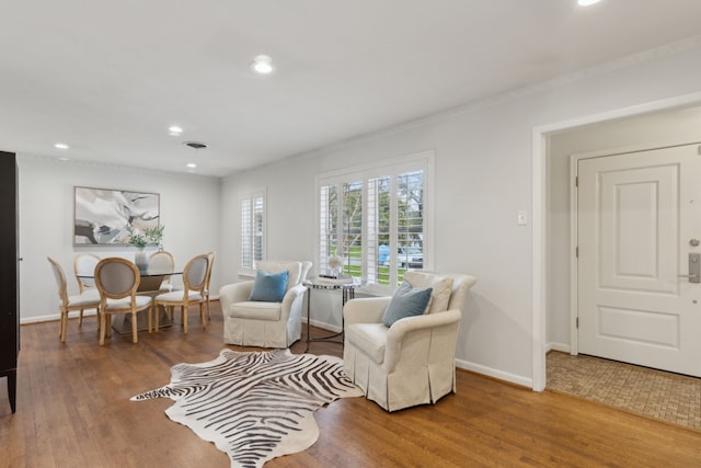 sitting room featuring ornamental molding, wood finished floors, and baseboards