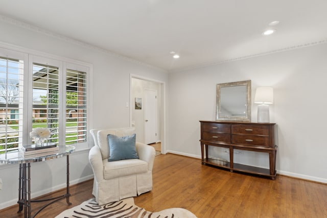 living area with baseboards, wood finished floors, and recessed lighting