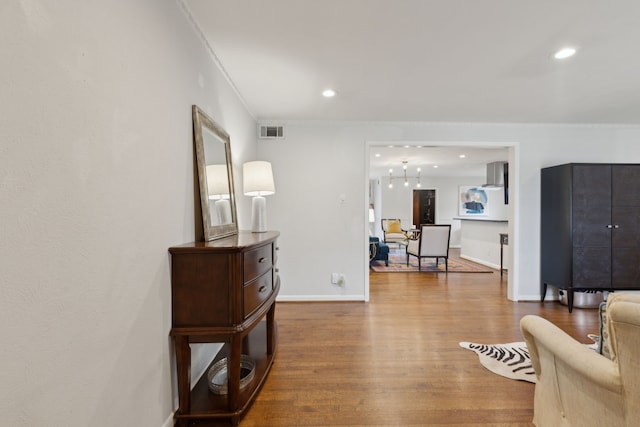 interior space featuring baseboards, visible vents, ornamental molding, wood finished floors, and recessed lighting