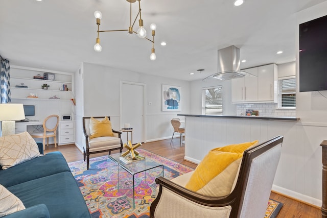 living area with baseboards, wood finished floors, and recessed lighting