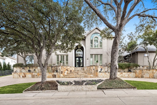 view of front of property with fence and french doors