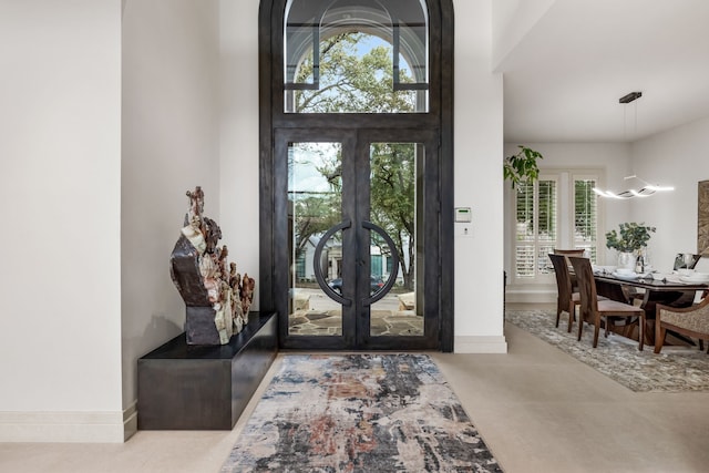 foyer featuring baseboards and french doors