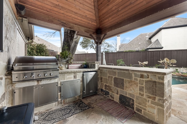 17704 Cedar Creek Canyon Dr, Dallas, TX 75252 - view of patio / terrace with exterior kitchen, a fenced backyard, and area for grilling