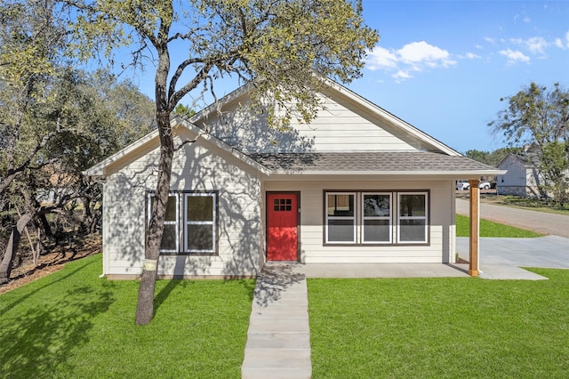 view of front of property with a front lawn and roof with shingles