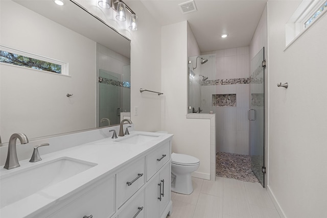 bathroom with a stall shower, visible vents, a sink, and toilet