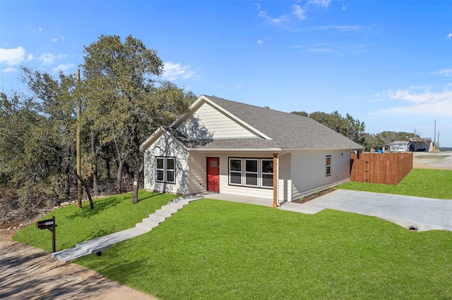 view of front of property featuring roof with shingles and a front yard