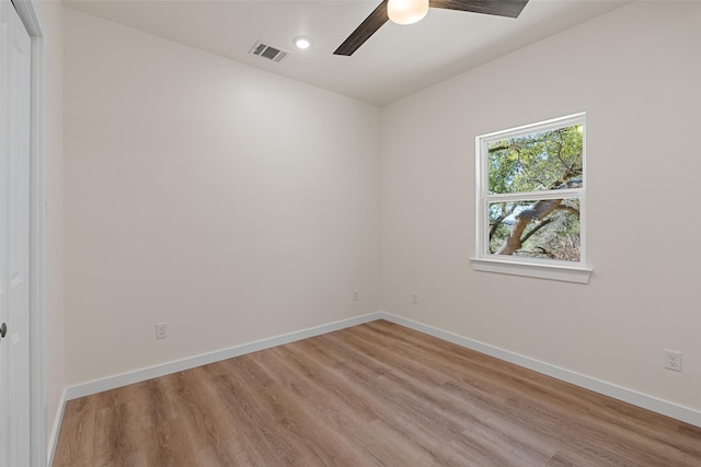 unfurnished room with a ceiling fan, visible vents, light wood-style flooring, and baseboards