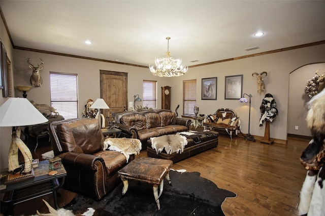 living room with baseboards, visible vents, hardwood / wood-style flooring, ornamental molding, and an inviting chandelier