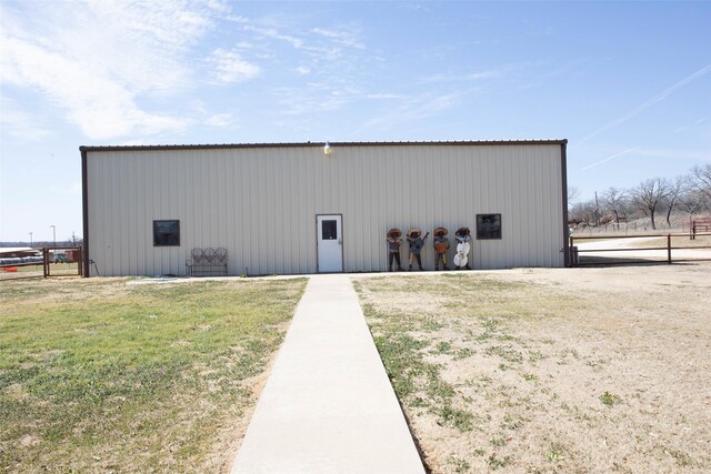 view of pole building with a yard and fence