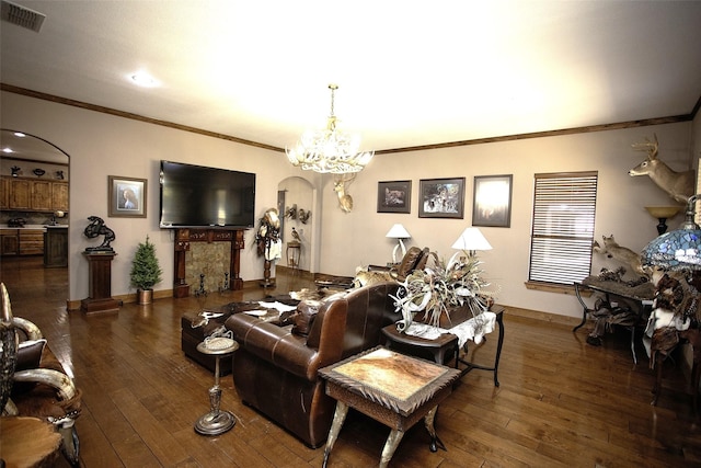 living area featuring hardwood / wood-style flooring, visible vents, arched walkways, and a chandelier