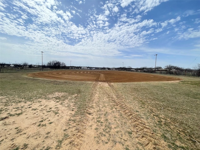 view of yard with fence and a rural view