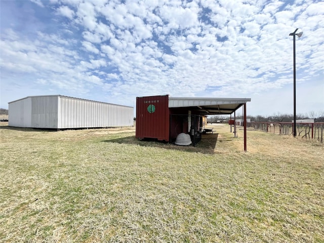 view of pole building featuring fence and a lawn