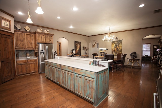 kitchen with arched walkways, light countertops, stainless steel refrigerator with ice dispenser, and visible vents