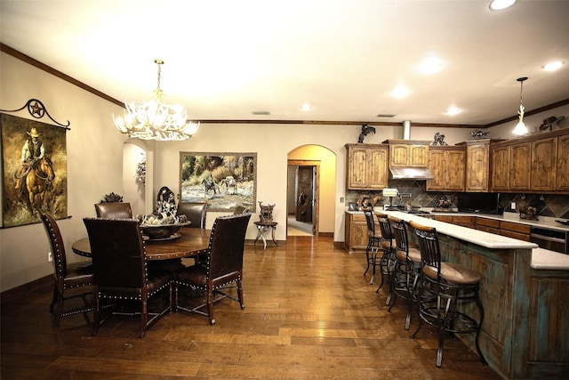 dining room featuring arched walkways, a chandelier, baseboards, ornamental molding, and dark wood-style floors