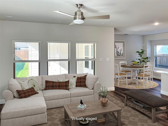 living area with wood finished floors, a ceiling fan, and baseboards