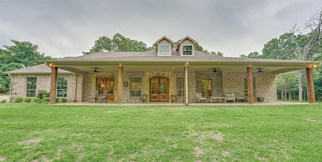 rear view of house featuring brick siding, ceiling fan, a patio, and a yard