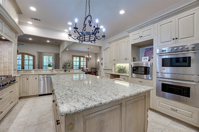 kitchen featuring tasteful backsplash, visible vents, an inviting chandelier, appliances with stainless steel finishes, and a kitchen island