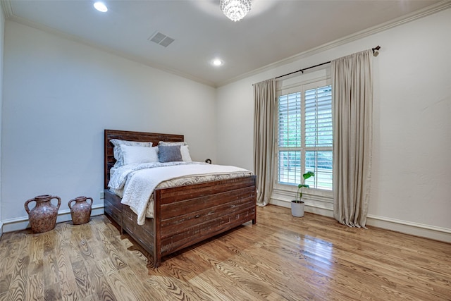 bedroom with recessed lighting, wood finished floors, visible vents, baseboards, and crown molding