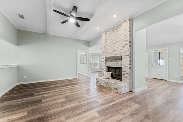 unfurnished living room with wood finished floors, visible vents, baseboards, a brick fireplace, and beam ceiling