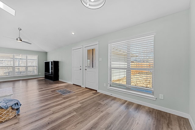 unfurnished living room featuring lofted ceiling, wood finished floors, a ceiling fan, and baseboards