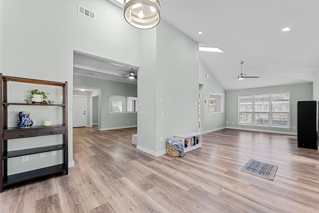 living area with baseboards, visible vents, a ceiling fan, wood finished floors, and high vaulted ceiling