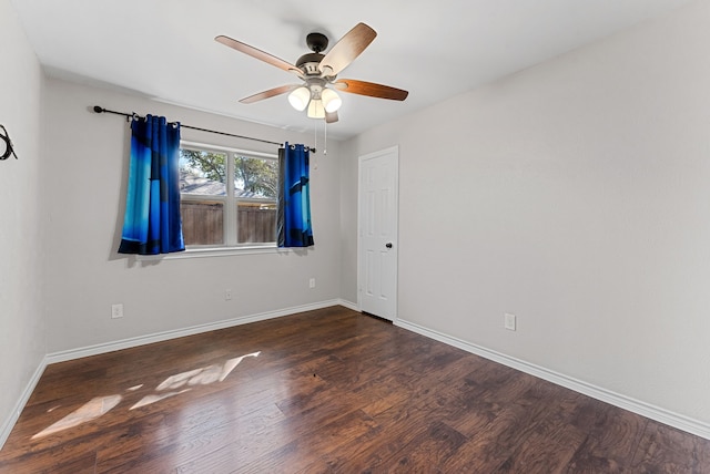 spare room with wood finished floors, a ceiling fan, and baseboards