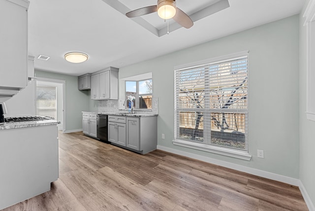 kitchen featuring visible vents, backsplash, dishwasher, and gray cabinetry