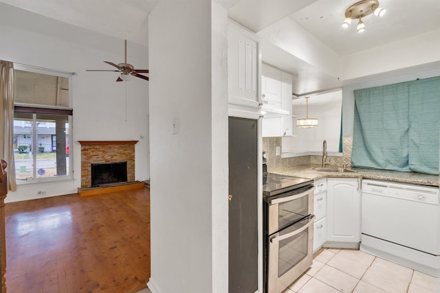 kitchen featuring backsplash, white cabinets, a sink, double oven range, and dishwasher