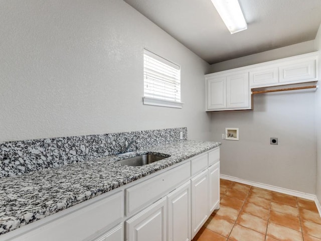 laundry area featuring hookup for a washing machine, a sink, baseboards, cabinet space, and electric dryer hookup