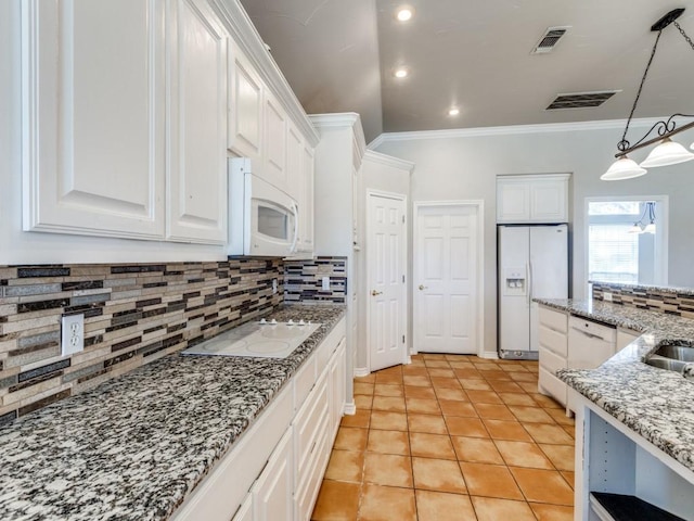 kitchen with tasteful backsplash, white appliances, visible vents, and white cabinetry