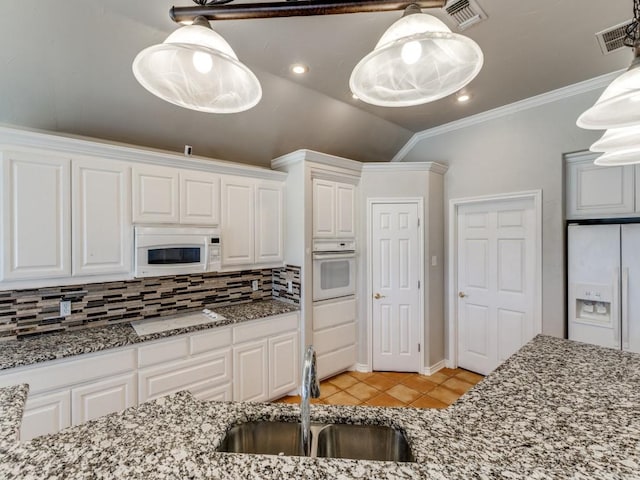 kitchen with light tile patterned floors, visible vents, backsplash, a sink, and white appliances