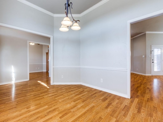 unfurnished room featuring a chandelier, baseboards, crown molding, and light wood finished floors