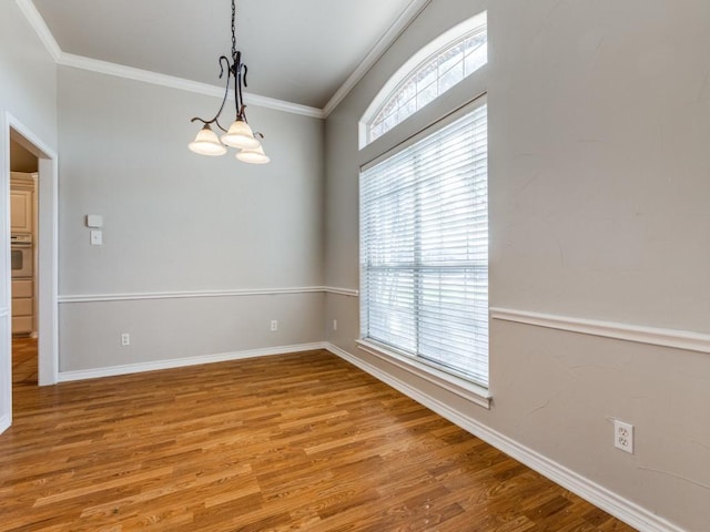 unfurnished room with ornamental molding, baseboards, and wood finished floors