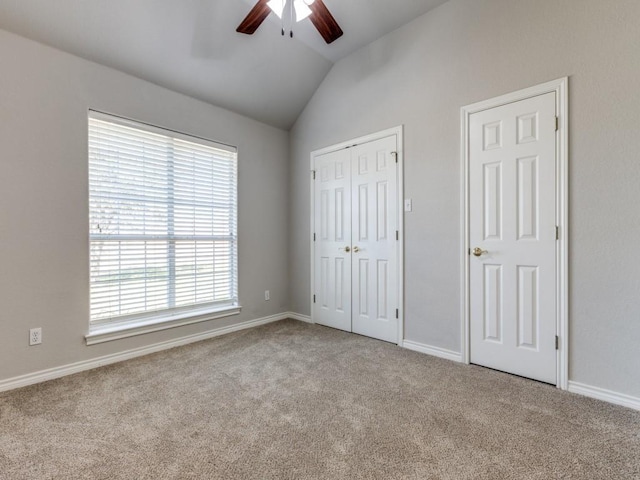 unfurnished bedroom featuring baseboards, a ceiling fan, lofted ceiling, carpet, and a closet