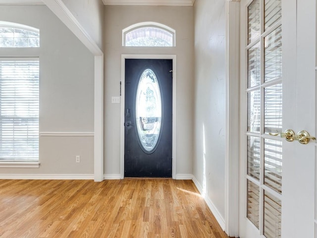 foyer entrance featuring baseboards and light wood finished floors